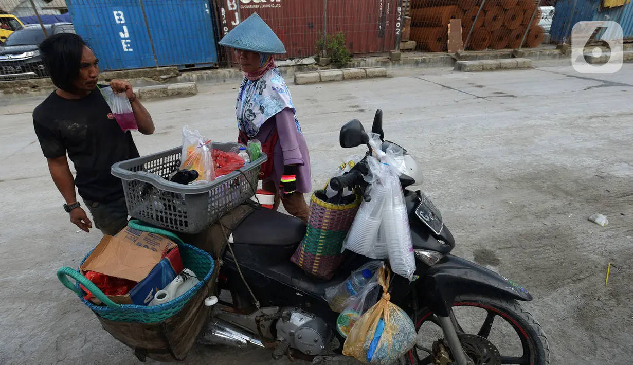Pedagang kopi keliling atau dikenal dengan sebutan starling melayani pembeli di Pelabuhan Sunda Kelapa, Jakarta, Sabtu (7/12/2019). Pedagang yang mematok harga antara Rp 3.000 - Rp 7.000 ini menyasar buruh angkut Pelabuhan Sunda Kelapa. (merdeka.com/Imam Buhori)