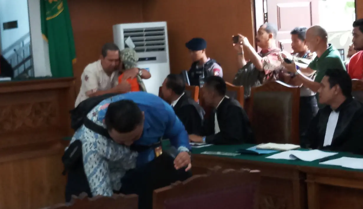 Korban ledakan bom di Jalan MH Thamrin pada Januari 2016, Ipda Denny Mahieu memeluk terdakwa Aman Abdurrahman di PN Jakarta Selatan, Jumat (23/2). Ipda Denny menjadi saksi kasus terorisme dengan terdakwa Aman Abdurrahman. (Liputan6.com/Ady Anugrahadi)