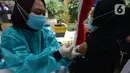 Polisi menyuntikkan vaksin virus corona COVID-19 kepada pedagang Pasar Induk Kramat Jati di Jakarta Timur, Kamis (22/7/2021). Sebanyak 250 pedagang Pasar Induk Kramat Jati menjalani vaksinasi guna menekan penyebaran COVID-19. (merdeka.com/Imam Buhori)