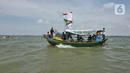 Sejumlah nelayan bersiap untuk melarung replika kapal berisi sesaji di Pantai Tarumajaya, Kabupaten Bekasi, Jawa Barat, Jumat (28/1/2022). Ritual ini diikuti sebanyak 40 kapal nelayan dari enam Muara. (Liputan6.com/Herman Zakharia)