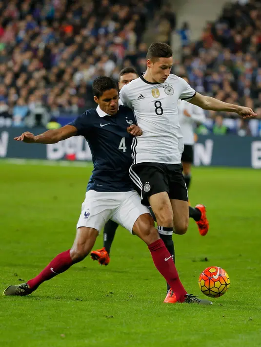 Gelandang Jerman, Julian Draxler (kanan) berusaha melewati bek Perancis, Raphael Varane pada laga persahabatan di stadion Stade de France, Perancis, (13/11). Perancis menang atas Jerman dengan skor 2-0. (REUTERS/Gonzalo Fuentes)