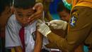 Seorang murid bereaksi saat menerima vaksin difteri di sebuah sekolah dasar di Surabaya pada Selasa 4 November 2025. Dalam pelaksanaannya, tim dari Puskesmas akan mendatangi sekolah sesuai jadwal yang telah ditentukan. Sementara, orang tua/wali murid akan menerima pemberitahuan resmi dari sekolah jauh-jauh hari sebelum imunisasi dilaksanakan. (Juni KRISWANTO/AFP)