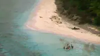 Tiga pelaut diselamatkan AL AS dari Pulau Fanadik, Mikronesia, di Pasifik, setelah menuliskan "help" menggunakan dahan pohon palem, 7 April 2016. Mereka sudah tiga hari terdampar setelah kapal yang ditumpangi tersapu ombak. (ENSIGN JOHN KNIGHT/NMCO/AFP)