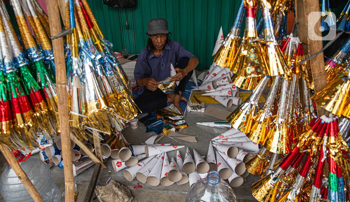 Pedagang menyelesaikan pembuatan terompet di kawasan Glodok, Jakarta, Selasa (26/12/2023). (Liputan6.com/Faizal Fanani)