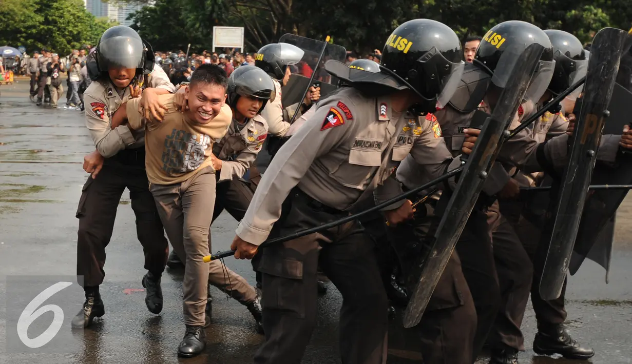 Polda Metro Jaya melakukan simulasip engamanan pelaksanaan Pilkada Serentak 2015 di Parkir Timur Senayan, Jakarta, Kamis (6/8/2015). Tampak, simulasi pengamanan tersangka provokator aksi massa pasca pemungutan suara. (Liputan6.com/Helmi Fithriansyah)