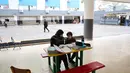 Eskalasi serangan udara Israel telah menyebabkan penutupan sekolah di Lebanon secara luas. Tampak dalam foto, seorang wanita Lebanon yang mengungsi duduk di samping seorang anak, mengawasi pelajaran daringnya melalui telepon seluler di sebuah sekolah negeri yang diubah menjadi tempat penampungan di kota Dekwaneh, utara Beirut, pada Rabu 25 Maret 2026. (Anwar AMRO/AFP)
