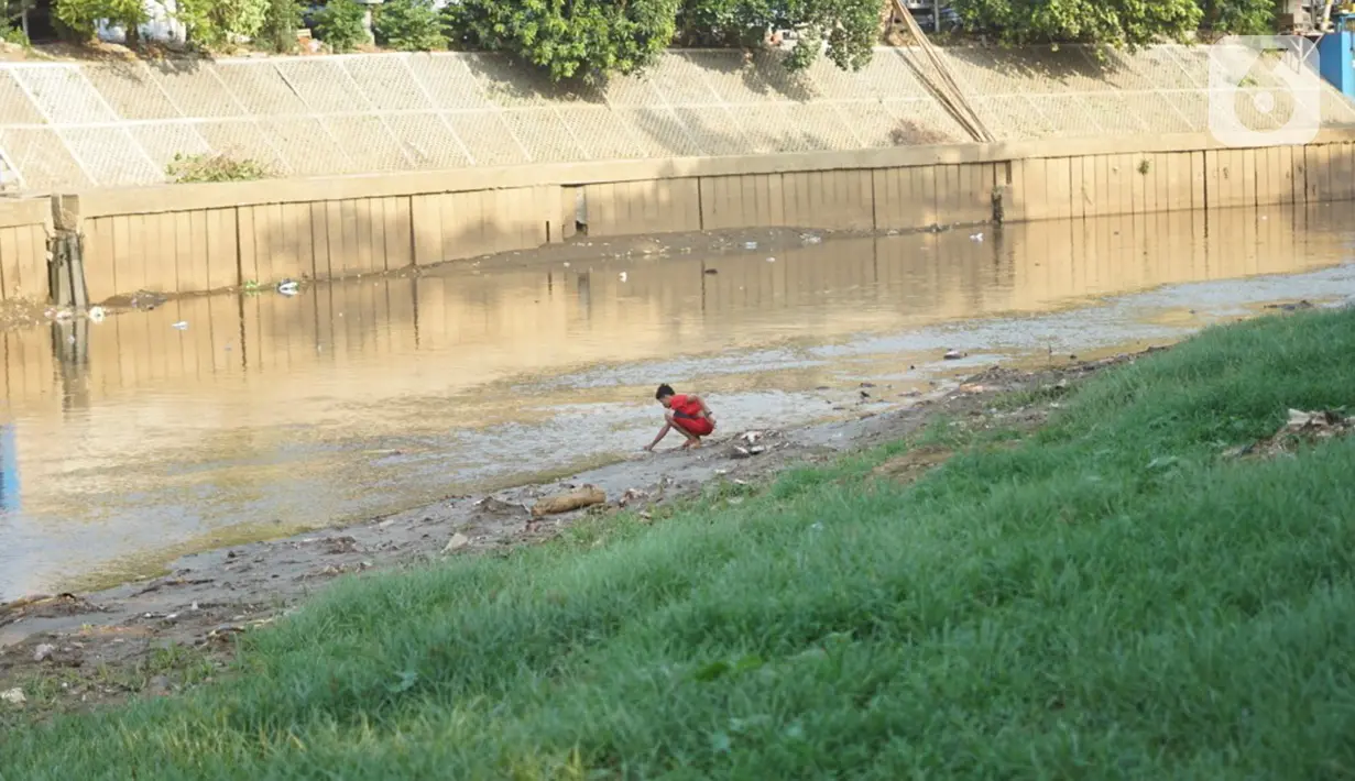 Anak-anak bermain di bantaran Sungai Ciliwung yang mengering, kawasan Kampung Melayu, Jakarta, Jumat (8/11/2019). Curah hujan yang tidak menentu menyebabkan sebagian bantaran Ciliwung masih mengalami kekeringan. (Liputan6.com/Immanuel Antonius)