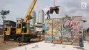 Seniman Teguh Ostenrik (kanan) mengawasi pemasangan pecahan Tembok Berlin dan Patung Menembus Batas di RPTRA Kalijodo, Jakarta, Selasa (26/9). Hal ini bertujuan agar masyarakat bisa melihat langsung tembok bersejarah itu. (Liputan6.com/Immanuel Antonius)