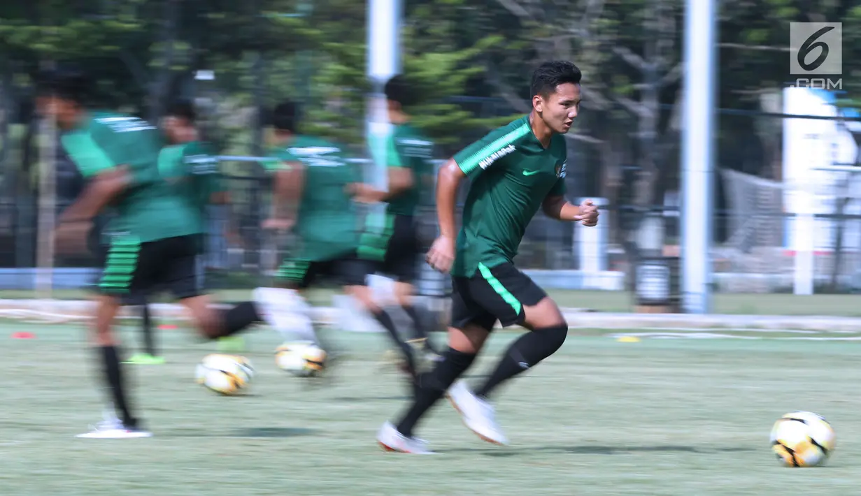 Pemain Timnas Indonesia U-19, Syahrian Abimanyumelakukan pemanasan saat latihan di Lapangan B Kompleks GBK, Jakarta, Selasa (18/9). Latihan ini persiapan  PSSI Anniversary Cup U-19 dan Piala AFC U19. (Liputan6.com/Helmi Fithriansyah)