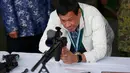 Presiden Filipina Rodrigo Duterte mencoba senapan sniper CS / LR4A buatan China di Clark Airbase di Filipina (28/6). Bantuan militer tersebut akan digunakan untuk melawan ancaman terorisme dan pembajakan dari kelompok militan. (AP Photo/Bullit Marquez)