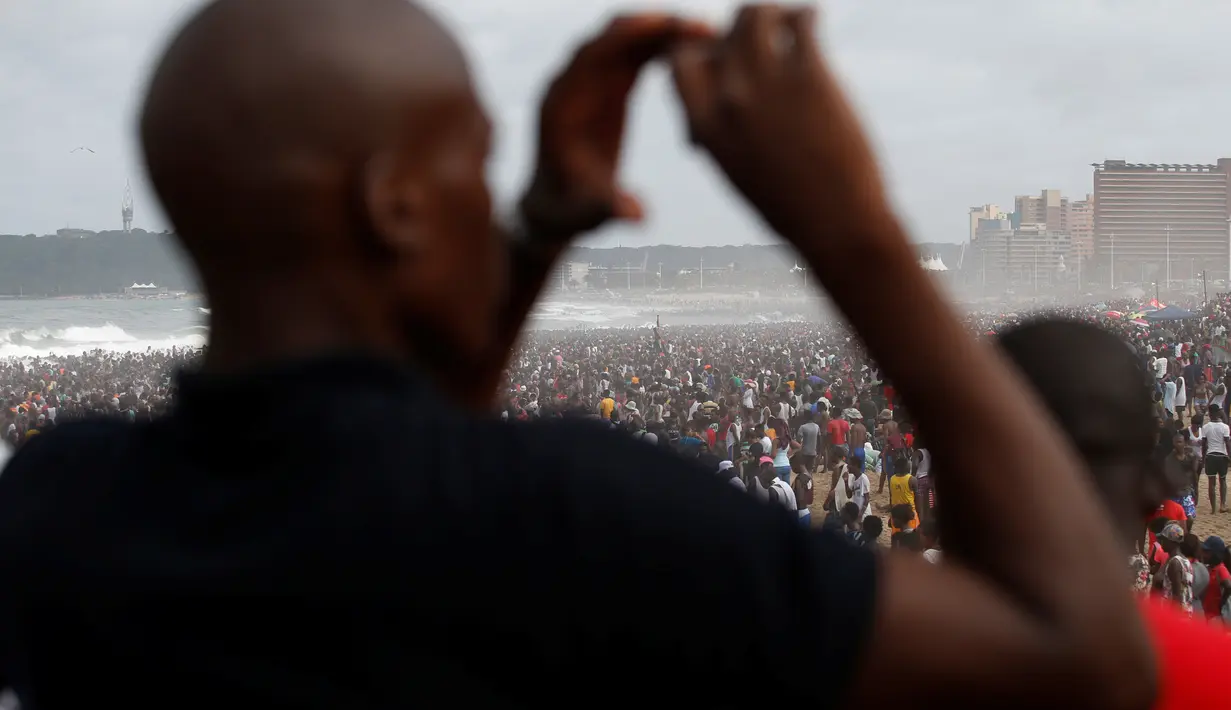 Pengunjung mengabadikan keramaian saat liburan awal Tahun Baru 2017 di sebuah pantai di Durban, Afrika Selatan (1/1). (REUTERS/Rogan Ward)