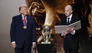 (Kiri/Kanan) Presiden AS, Donald Trump, memperhatikan saat menerima Hadiah Perdamaian FIFA (FIFA Peace Award) dari Presiden FIFA, Gianni Infantino, selama pengundian Piala Dunia 2026 yang berlangsung di AS, Kanada, dan Meksiko, di Kennedy Center, Washington, DC, pada 5 Desember 2025. (Brendan SMIALOWSKI/AFP)