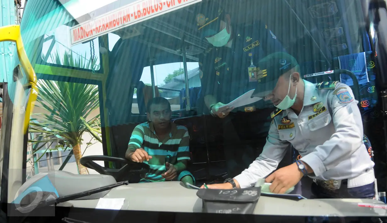 Petugas memeriksa kelengkapan surat armada bus yang akan diterjunkan untuk arus mudik di Tangsel, Rabu (29/6). Pemeriksaan tersebut guna mengetahui kelayakan angkutan mudik agar tidak membahayakan jiwa pemudik. (Liputan6.com/Helmi Afandi)