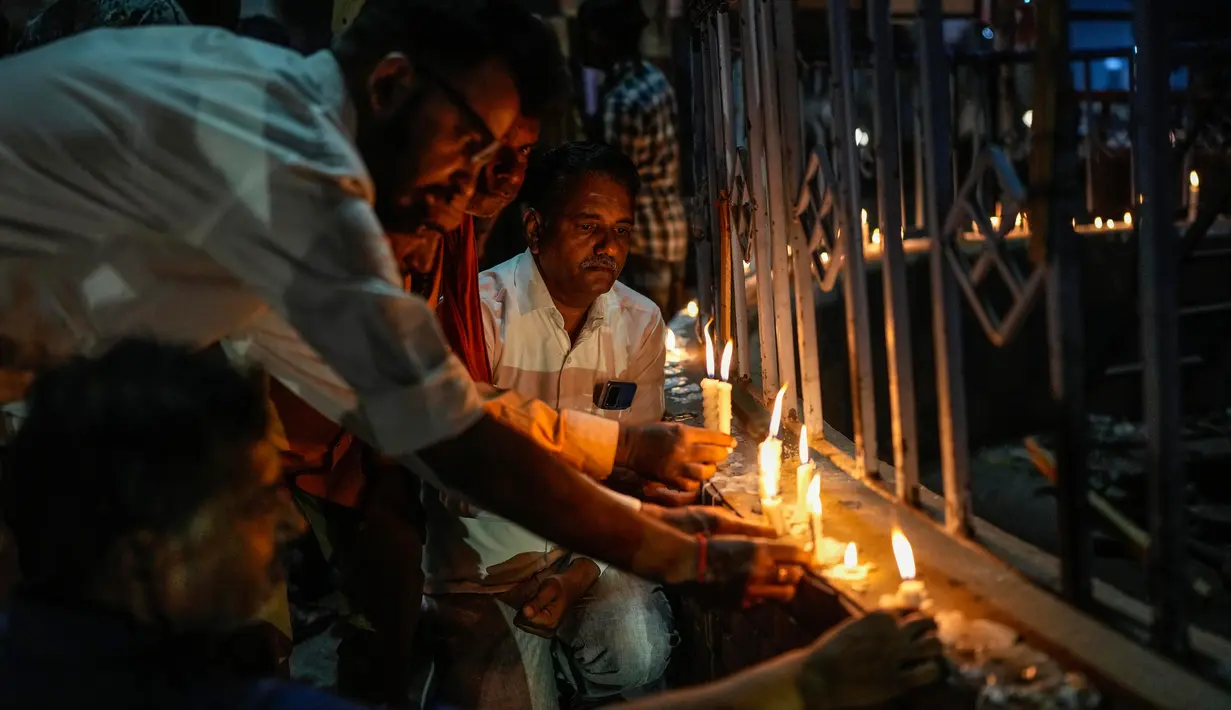 <p>Orang-orang menyalakan lilin untuk memberi penghormatan kepada para korban ambruknya jembatan di New Delhi, India, Senin (31/10/2022). Jembatan gantung tersebut ambruk pada 31 Oktober 2022 malam, yang menyebabkan ratusan orang jatuh ke sungai. (AP Photo/Rafiq Maqbool)</p>