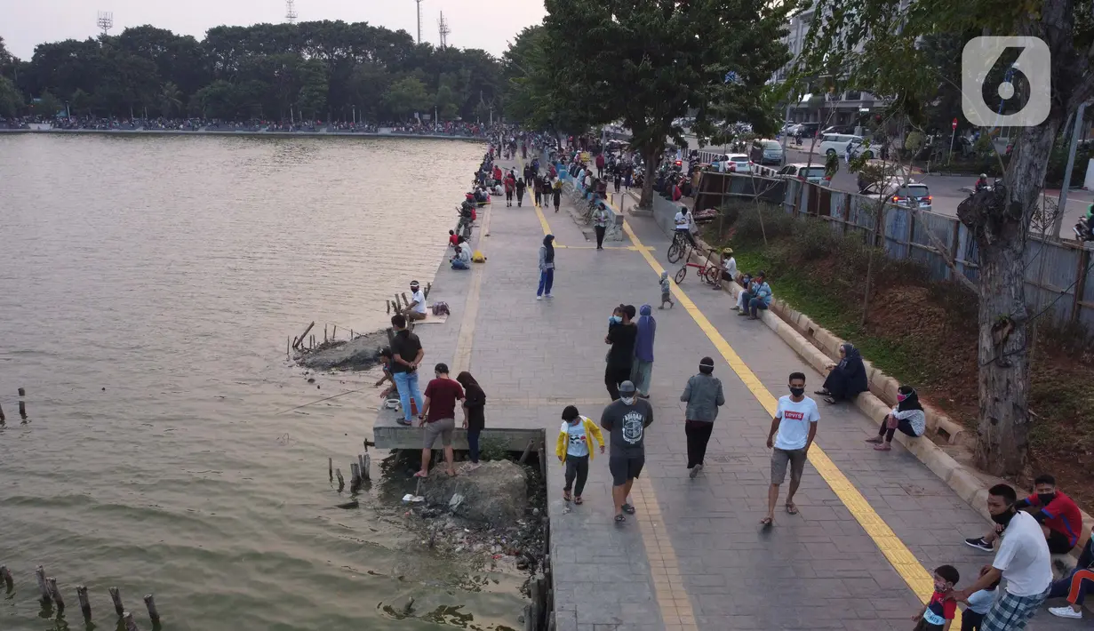 Foto udara memperlihatkan aktivitas warga di pedestrian Danau Sunter, Jakarta, Sabtu (27/6/2020). Beragam aktivitas dilakukan warga sambil menikmati waktu sore di area Danau Sunter, Jakarta. (Liputan6.com/Helmi Fithriansyah)