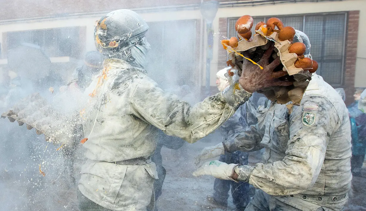Orang-orang yang mengenakan pakaian militer ikut serta dalam perang makanan "Els Enfarinats" di Kota Ibi, Spanyol, 28 Desember 2022. Dalam festival musim dingin ini para peserta mengenakan pakaian militer dan mementaskan tiruan kudeta di luar balai kota. (JAIME REINA/AFP)