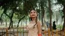 Ia nampak kenakan gaun H-Line berwarna nude peach dengan embellishment bunga kecil pada rok [@noviabachmid]