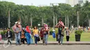 Rombongan warga berjalan-jalan di kawasan Monumen Nasional, Jakarta, Minggu (25/12). Libur perayaan Natal 2016 dimanfaatkan sejumlah warga untuk berwisata di kawasan Monumen Nasional. (Liputan6.com/Helmi Fithriansyah)