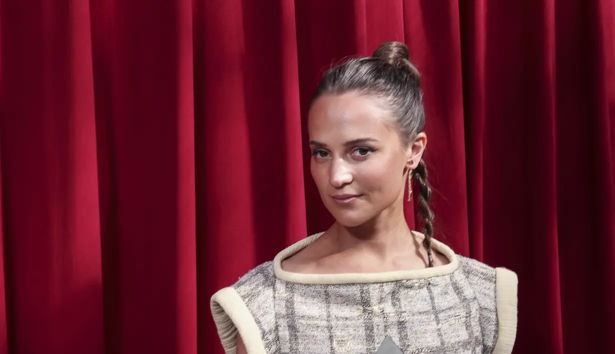 Alicia Vikander berpose saat menghadiri koleksi busana Louis Vuitton Spring/Summer 2023 selama Paris Fashion Week di Paris pada Selasa, 4 Oktober 2022. Ia cantik dalam balutan sweater bermotif tanpa lengan dan celana kargo berpinggang tinggi saat ia memasuki acara eksklusif tersebut. (AP Photo/Francois Mori)