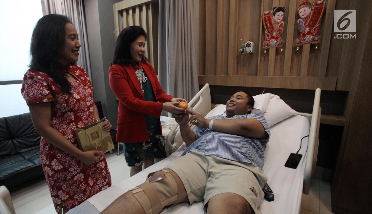 Kepala Divisi Pengembangan Bisnis RS Siloam Triana Tambunan (kiri) bersama Dokter RS Siloam Susilawati (kanan) memberikan jeruk pada pasien di RS Siloam, Semanggi, Jakarta, Kamis (15/2).  Hal ini dalam rangka merayakan Imlek. (Liputan6.com/Arya Manggala)