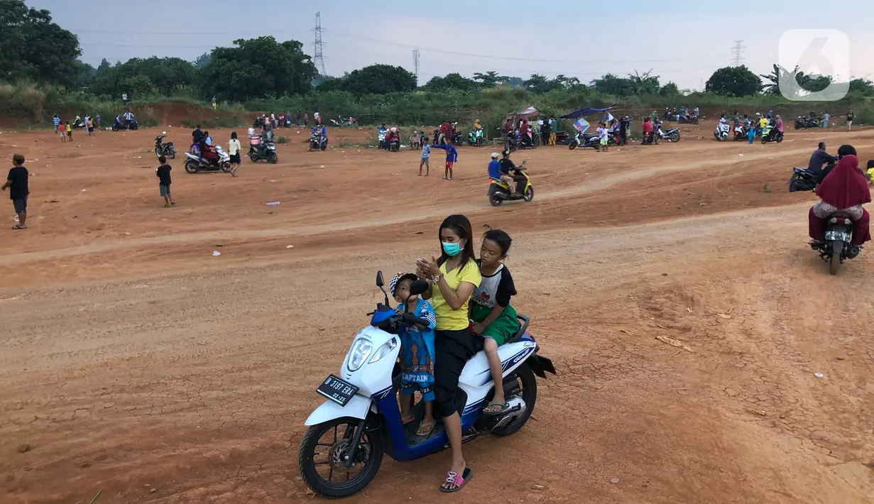 Warga menghabiskan waktu di tanah lapang kawasan Cipayung, Depok, Kamis (11/6/2020). Kurang tegasnya sanksi serta minimnya kesadaran masyarakat akan protokol kesehatan terkait covid-19 menyebabkan kawasan itu menjadi tempat berkerumun warga setiap sore hari. (Liputan6.com/Immanuel Antonius)