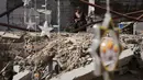 Beberapa pengungsi membuat lentera Ramadan dari kaleng bekas atau kain selimut bantuan. Tampak dalam foto, seorang wanita Palestina memperhatikan orang lain menggantung hiasan Ramadan di samping reruntuhan rumah yang hancur di Khan Younis, Jalur Gaza selatan, Minggu 15 Februari 2026. (AP Photo/Abdel Kareem Hana)