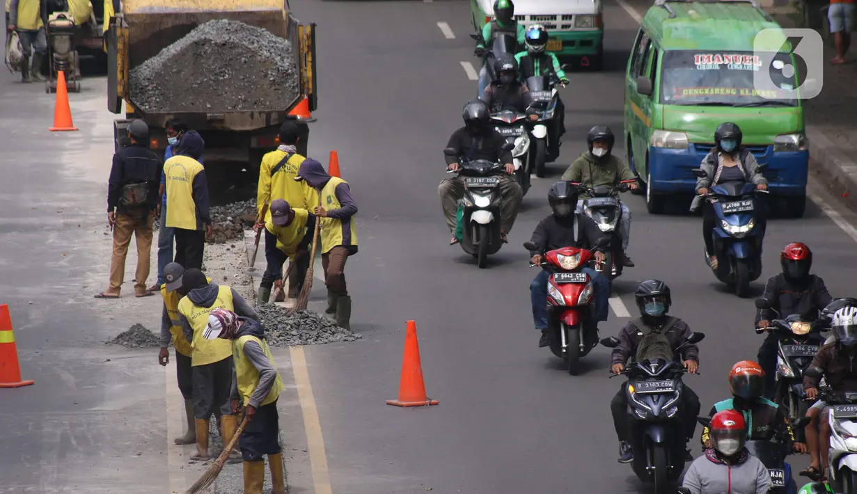 Pekerja melakukan penataan di ruas jalan nasional di Jalan Daan Mogot, Kota Tangerang, Banten, Selasa (15/2/2022). Pemkot Tangerang berencana melakukan sistem satu arah di Jalan Daan Mogot untuk mengatasi kemacetan di akses masuk tol Cengkareng-Batu Ceper-Kunciran. (Liputan6.com/Angga Yuniar)