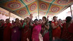 Beberapa perempuan bernyanyi dan menari di kuil Pashupatinath saat perayaan festival Teej di Kathmandu, (28/8/2014). Festival Teej dilakukan untuk memperingati penyatuan Dewa Siwa dan Dewi Parwati. (REUTERS/Navesh Chitrakar)