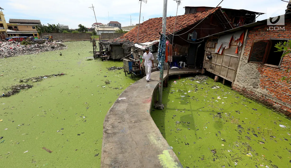 Siswa melintas di jembatan penyebrangan di kawasan Kampung Apung, Jakarta, Senin (6/11). Warga Kampung Apung berharap Gubernur DKI Jakarta Anies Baswedan menyediakan rumah yang layak. (Liputan6.com/JohanTallo)