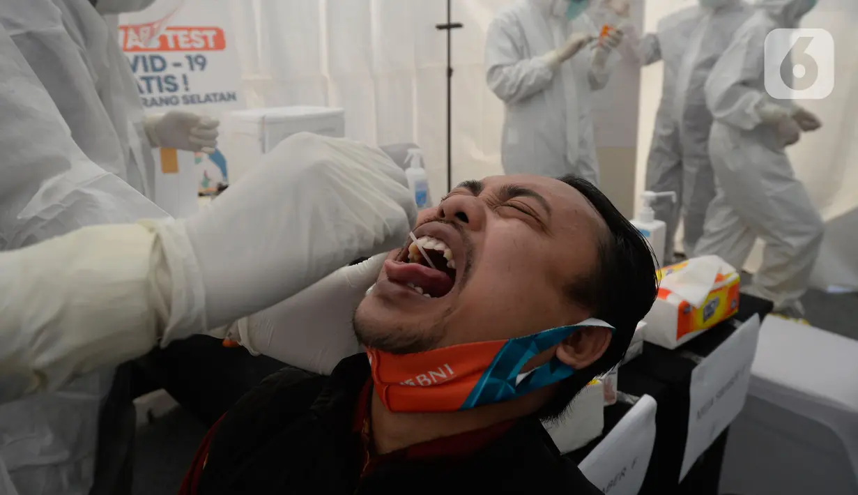 Petugas medis mengambil sempel lendir salah satu peserta test SWAB massal gratis di halaman Dinas Kesehatan Tangeramg Selatan, Banten, Minggu (30/8/2020). Test Swab gratis tersebut diikuti 750 orang untuk pencegahaan penyebaran Covid-19. (merdeka.com/Dwi Narwoko)
