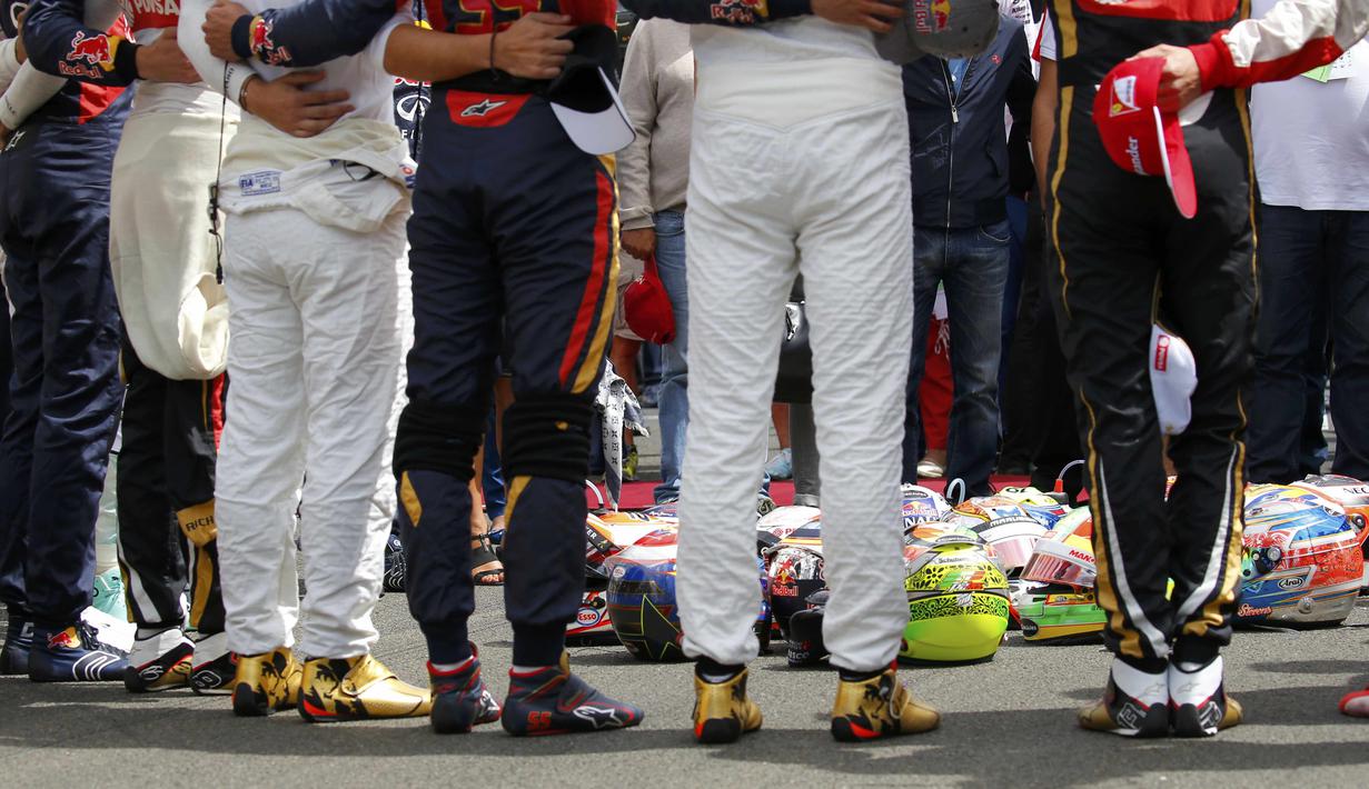 Para pebalap F1 meletakkan helm di tengah lingkaran saat mengheningkan cipta selama satu menit sebelum memulai balapan. (Reuters/Laszlo Balogh)