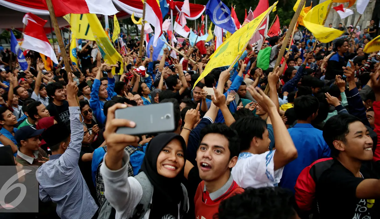Mahasiswa berselfie saat berkumpul dalam Apel Kebangsaan Mahasiswa Indonesia di Tugu Proklamasi, Jakarta, Kamis (3/11). Ribuan mahasiswa ini menyatakan sikap terhadap aksi 4 November besok agar berjalan dengan damai. (Liputan6.com/Johan Tallo)