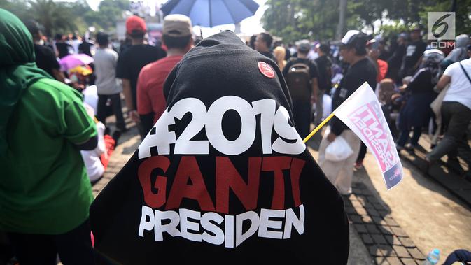 Massa menggunakan kaus bertulisakan #2019GantiPresiden saat deklarasi akbar di Monas, Jakarta, Minggu (6/5). Acara ini juga diramaikan dengan penjualan kaus dan atribut bertagline #2019GantiPresiden. (Merdeka.com/Iqbal Nugroho)