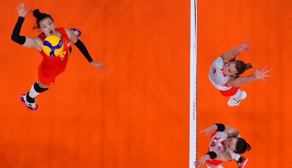 Atlet bola voli asal China Zhang Changning (kiri) melakukan spike saat bertanding melawan Turki pada babak penyisihan bola voli  putri Olimpiade Tokyo 2020 di Ariake Arena, Tokyo, Minggu (25/7/2021). (Foto: AFP/Yuri Cortez)