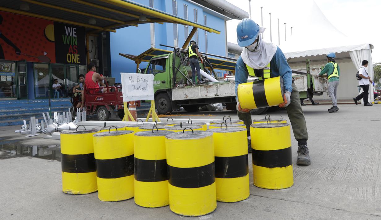Pekerja menyelesaikan persiapan untuk venue bulutangkis SEA Games 2019 di Muntinlupa Sports Center, Manila, Sabtu (23/11). Cabang bulutangkis akan mulai bertanding pada Minggu (1/12). (Bola.com/M Iqbal Ichsan)