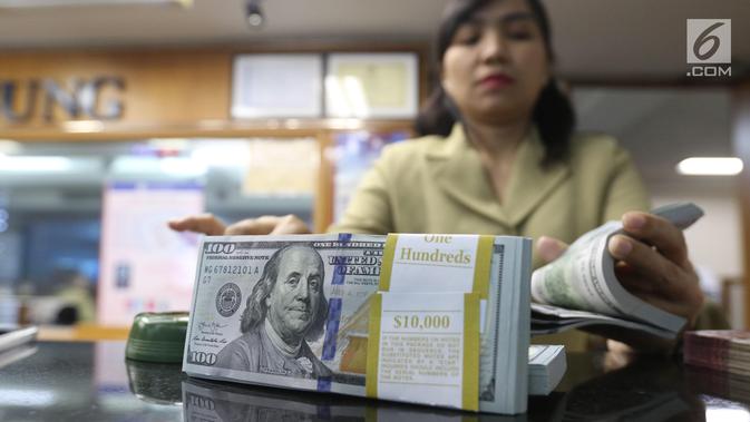 Pekerja menghitung mata uang Dolar AS di jasa penukaran uang asing di Jakarta, Rabu (19/6/2019). Nilai tukar rupiah terhadap Dolar AS sore ini Rabu (19/6) ditutup menguat sebesar Rp 14.269 per dolar AS atau menguat 56,0 poin (0,39 persen) dari penutupan sebelumnya. (Liputan6.com/Angga Yuniar)
