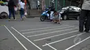 Seorang relawan dari Koalisi Pejalan Kaki membuat pola untuk jalur zebra cross di depan Stasiun Sudirman, Jakarta, Jumat (13/3/2015). (Liputan6.com/Faizal Fanani)