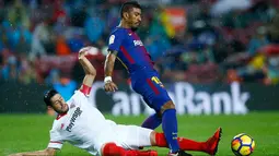 Gelandang Barcelona, Paulinho berusaha membawa bola dari kawalan pemain Sevilla, Sergio Escudero saat bertanding pada lanjutan La Liga Spanyol di Camp Nou, Barcelona, Spanyol, (4/11). Barcelona menang 2-1 atas Sevilla. (AP Photo/Manu Fernandez)