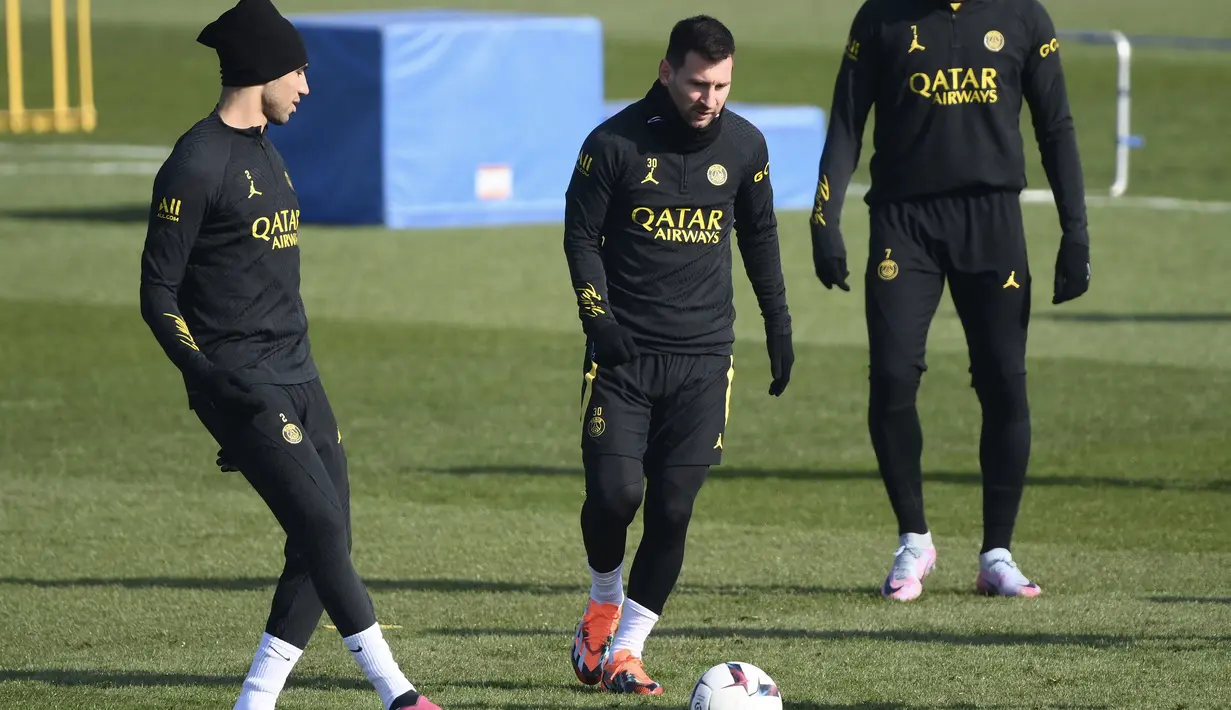 Bek PSG Achraf Hakimi (Kiri) memainkan bola dengan Lionel Messi saat sesi latihan jelang menjamu Nantes pada Liga Prancis, di tempat latihan klub di Saint-Germain-en-Laye, sebelah barat Paris, Jumat (3/3/2023). PSG yang saat ini berada di posisi puncak klasemen Liga Prancis 2022-23 sedang dalam momentum yang bagus. (Photo by FRANCK FIFE / AFP)