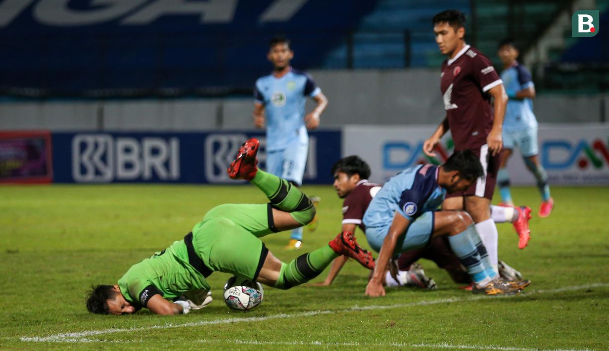 Kiper Persela Lamongan, Dwi Kuswanto (kiri) berusaha menyelamatkan bola saat menghadapi PSM Makassar dalam laga pekan ke-15 BRI Liga 1 2021/2022 di Stadion Moch. Soebroto, Magelang, Kamis (02/12/2021). (Bola.com/Bagaskara Lazuardi)
