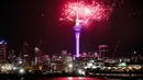 Kembang api meledak di atas Sky Tower di Auckland tengah saat perayaan Tahun Baru dimulai di Selandia Baru, Minggu (1/1/2022). Saat pergantian tahun, orang akan beramai-ramai melihat pertunjukan kembang api di langit yang berwarna-warni dan saling bersahutan. (Dean Purcel/NZ Herald via AP)