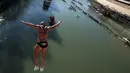 Seorang pria Italia bernama, Simone Carabella melompat ke Sungai Tiber dari jembatan Cavour, Roma, Italia (1/1). Lompatan ekstrem dari dari jembatan Cavour ke sungai Tiber menjadi tontonan warga sekitar. (Reuters/Alessandro Bianchi)