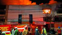 Petugas berusaha memadamkan kebakaran hebat yang melahap gudang toko di Jalan Gatot Subroto, Kota Malang, pada Rabu, 23 April 2025 (Liputan6.com/Zainul Arifin)