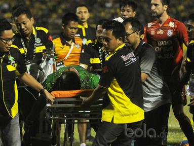 Aji Saka diangkut tim medis setelah menghantam tiang gawang sebelah kanan saat melawan Arema FC pada Liga 1 2017 di Gresik, (12/7/2017). (Bola.com/Iwan Setiawan). 