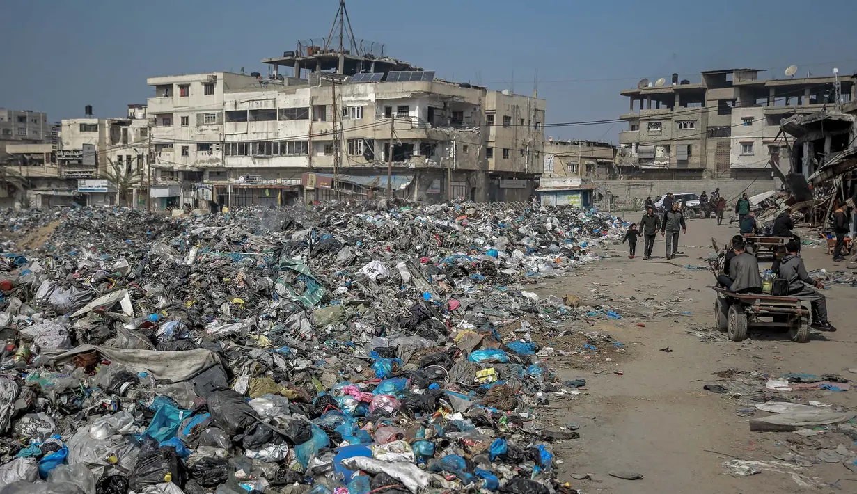 Sampah-sampah dibiarkan menumpuk di sepanjang jalan Kota Gaza hingga menuju lokasi pengungsian. (Foto oleh AFP)