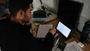 Untuk menjaga keberlangsungan pendidikan di tengah situasi keamanan yang tidak menentu, saat ini, proses belajar mengajar secara daring di Lebanon menjadi salah satu opsi utama. Tampak dalam foto, seorang pria Lebanon yang mengungsi melanjutkan studinya secara daring di sebuah sekolah negeri yang diubah menjadi tempat penampungan, di kota Dekwaneh, utara Beirut pada Rabu 25 Maret 2026. (Anwar AMRO/AFP)