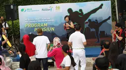 Instruktur mencotohkan gerakan body combat dalam acara sosialisasi bertajuk karnaval pekerja di area CFD, Jakarta, Minggu (14/5). Kegiatan tersebut dilakukan dalam rangka menyemarakkan Hari Pensiun Nasional. (Liputan6.com/Immanuel Antonius)