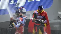 Marc Marquez dan Jorge Martin saat melakukan selebrasi di atas podium usai balapan MotoGP Prancis 2024. (JULIEN DE ROSA / AFP)