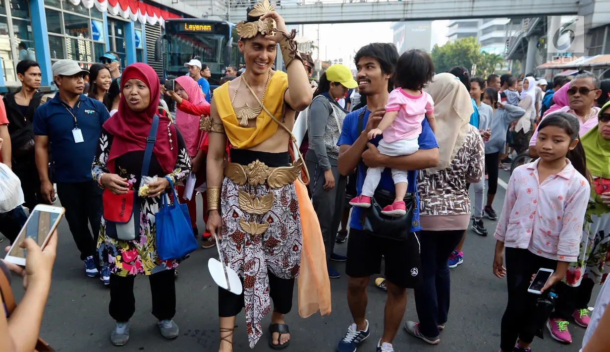 Karakter Brama Kumbara berinteraksi dengan warga saat pawai di area Car Free Day, Jakarta, Minggu (6/8). Pawai tersebut untuk mempromosikan sinetron laga Saur Sepuh The Series yang akan segera tayang di SCTV. (Liputan6.com/Fery Pradolo)