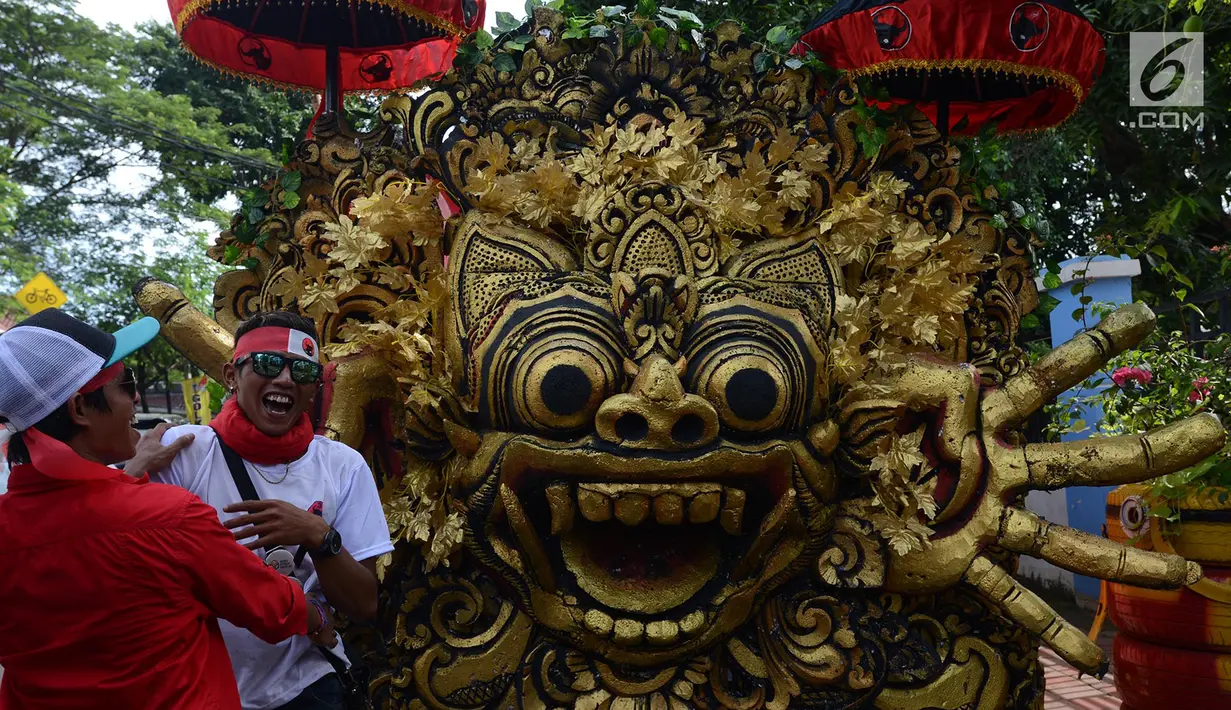 Pendukung capres -cawapres nomor urut 01 Jokowi-Ma'ruf Amin tertawa disamping mobil karnaval kampanye akbar di Jakarta Sabtu (13/4). Kampanye akbar bertajuk Konvensi Akbar Rakyat itu akan bermula dengan karnaval dari Bundaran HI hingga memasuki Stadion GBK. (merdeka.com/Imam Buhori)